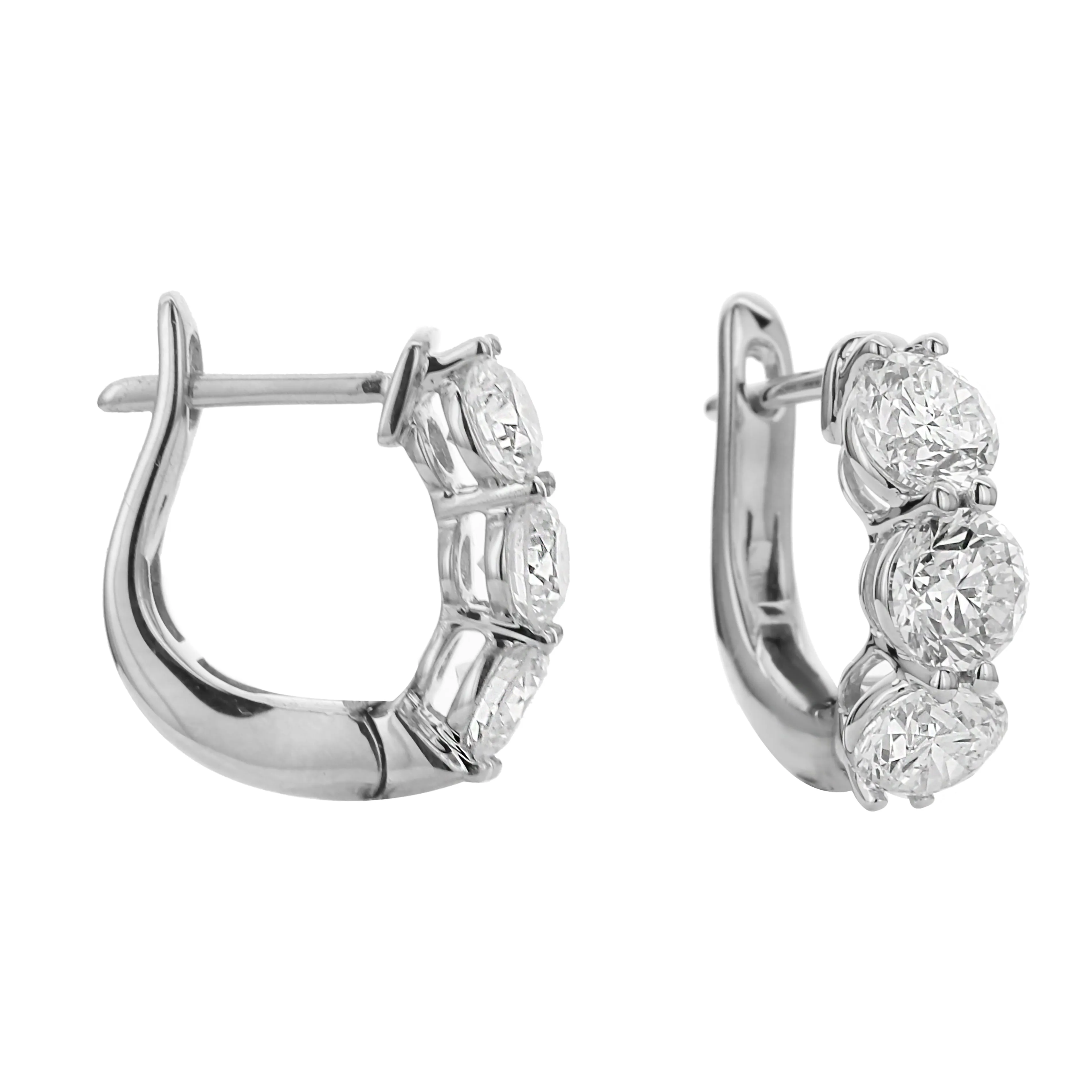 18KT white gold three stone hoop earrings with 1.50ctw round...