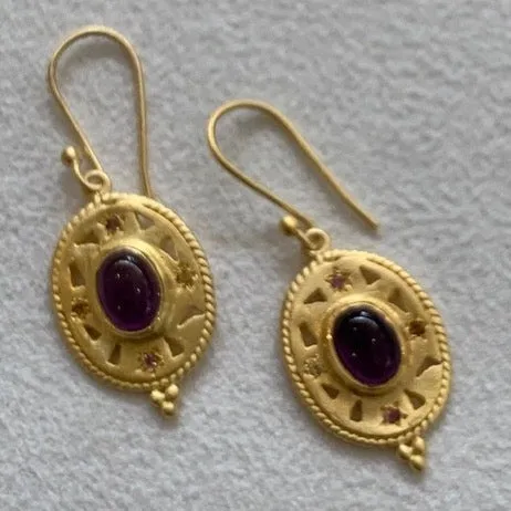 Gold with amethyst stone in the centre.