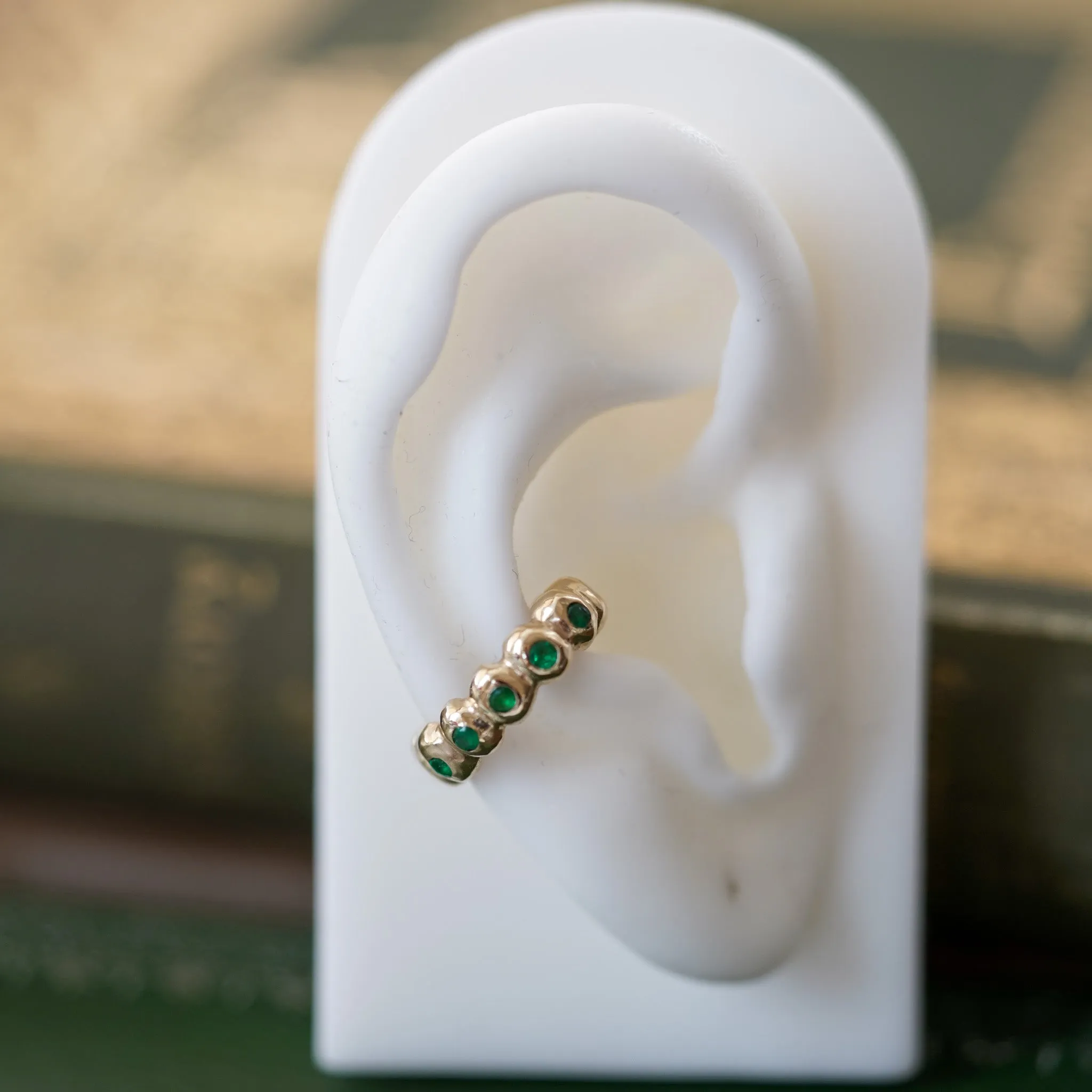Scalloped gold ear cuff with Emeralds